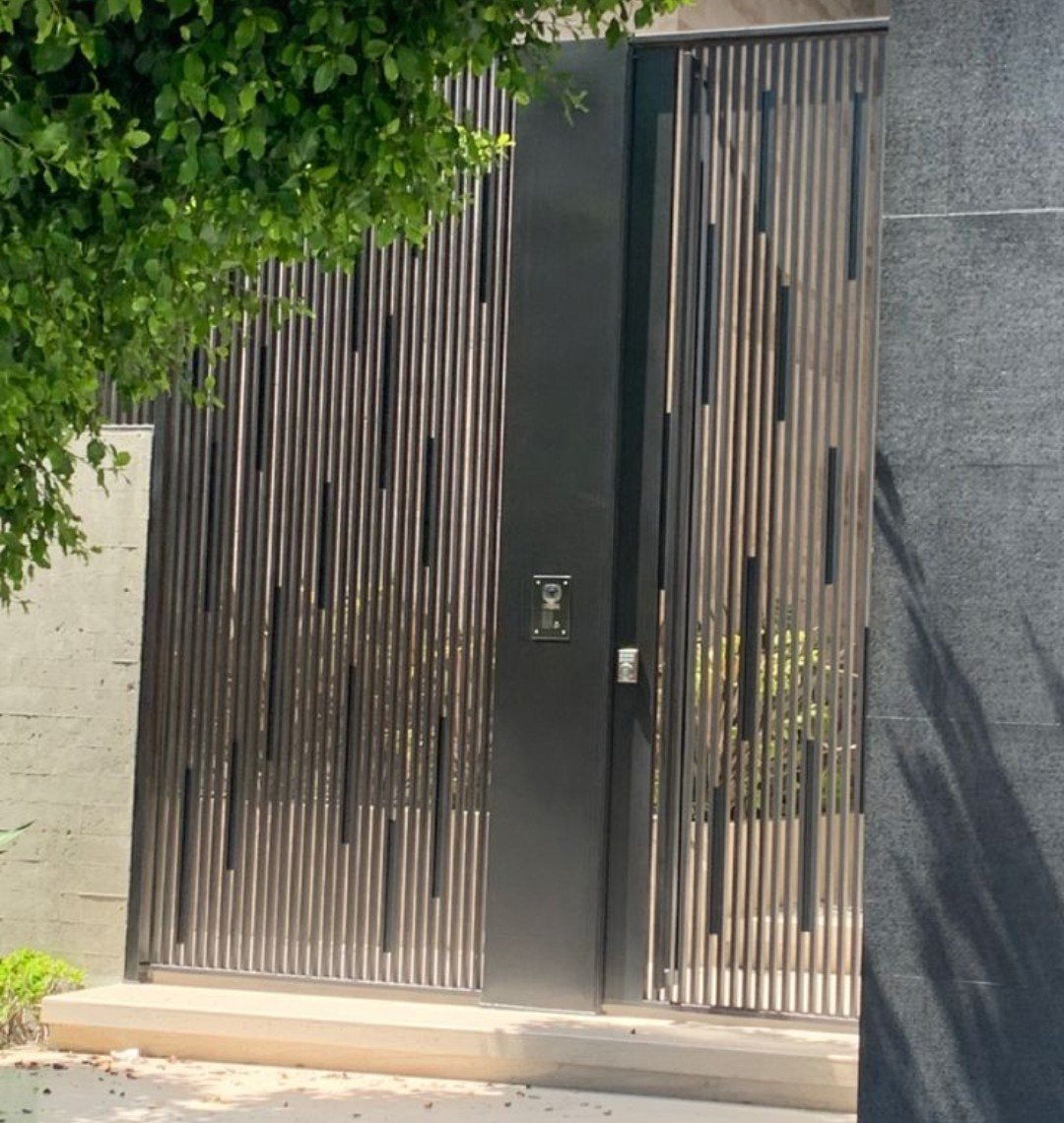 Portão em ripas verticais com detalhes pretos e interfone
